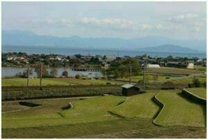 （信長に焼き討ちされた田畑や小さな村。右上に浮かぶ島の向こうに安土がある。）